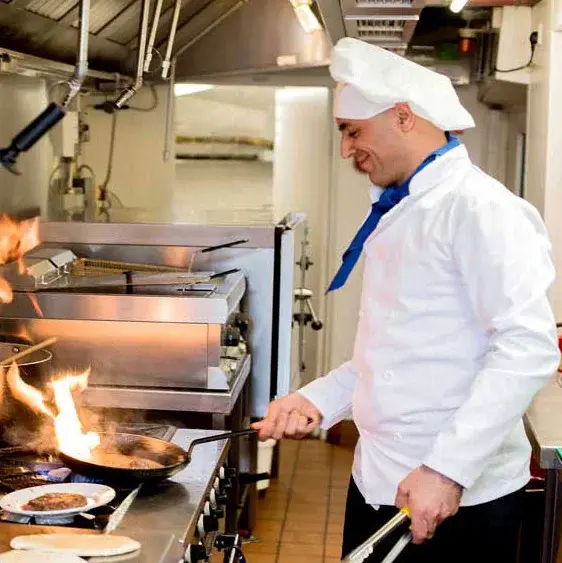 Colonial Gardens Chef Created Meals, chef frying a dish.