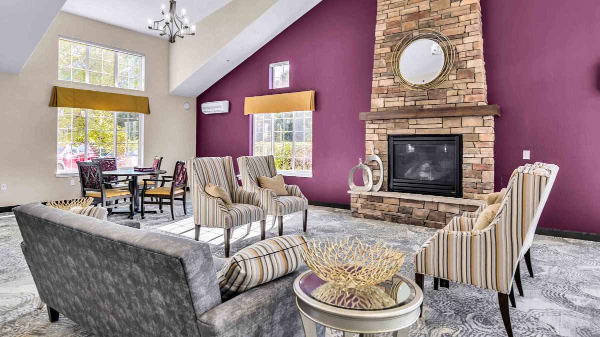 A cozy fireplace lounge at Colonial Gardens